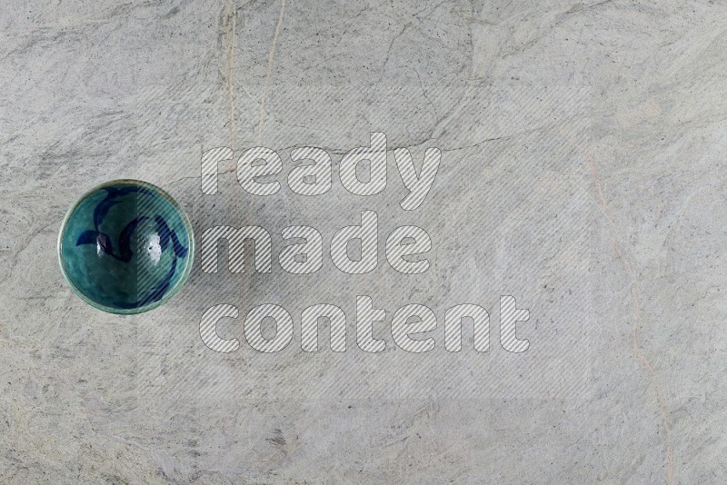 Top View Shot Of A Multicolored Pottery Bowl On Grey Marble Flooring