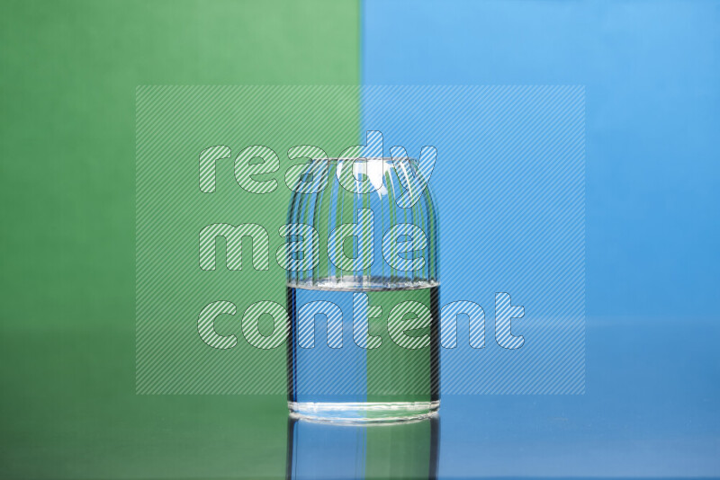 The image features a clear glassware filled with water, set against green and blue background