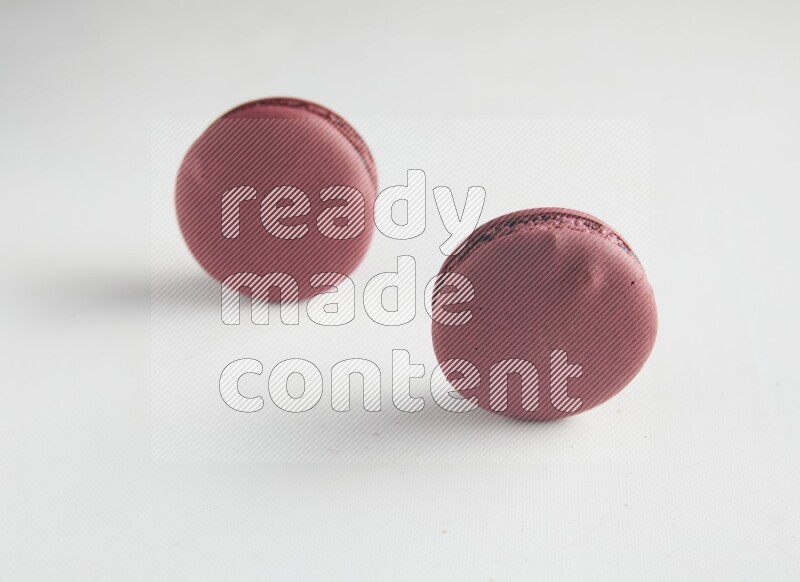 45º Shot of two Red Cherry macarons on white background