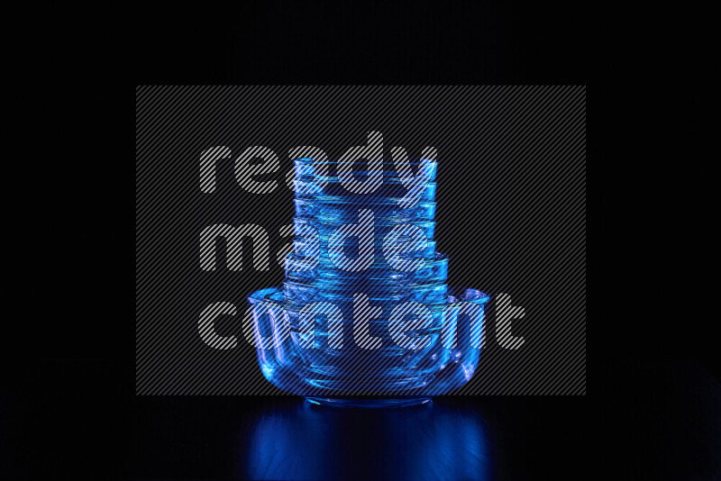 Glassware with rim light in blue against black background