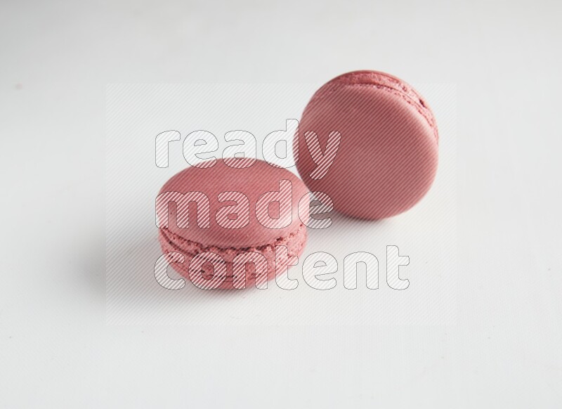 45º Shot of two Pink Raspberry macarons on white background