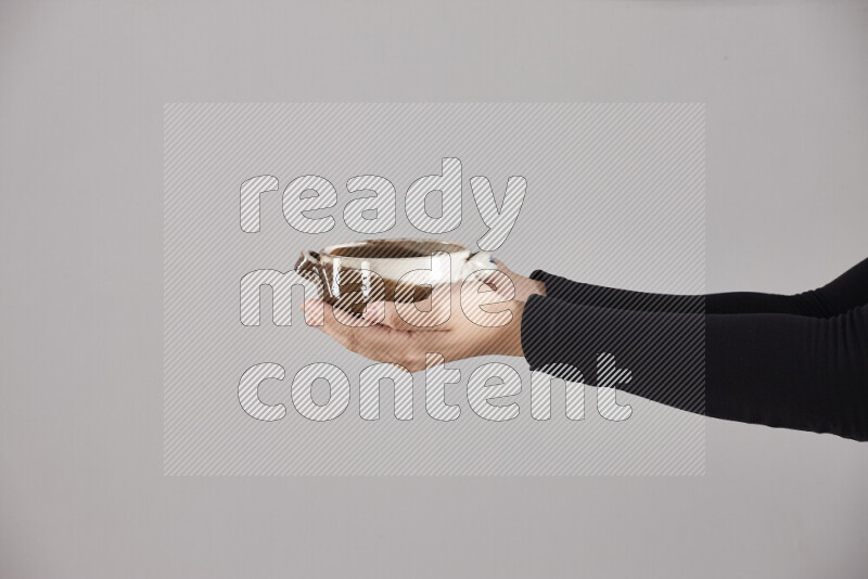 A woman in black abaya holding different pottery essentials in different positions