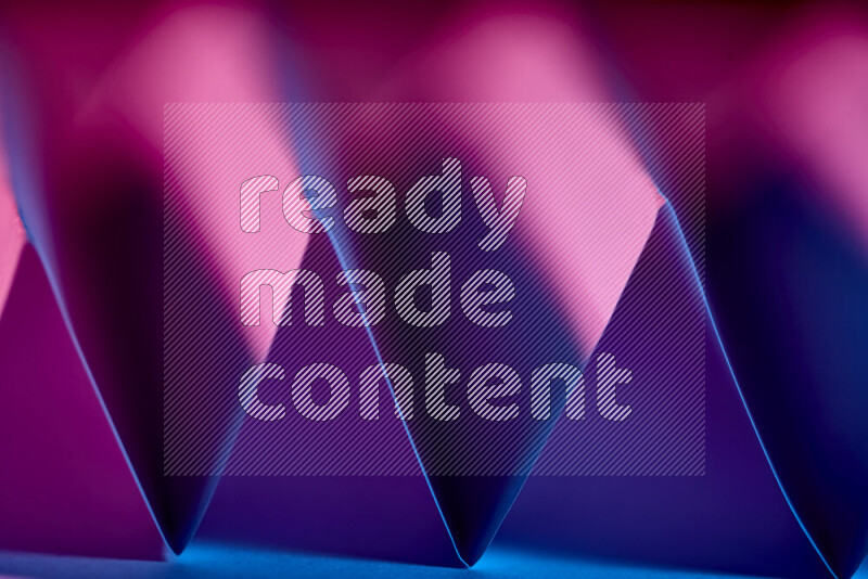 A close-up abstract image showing sharp geometric paper folds in purple gradients