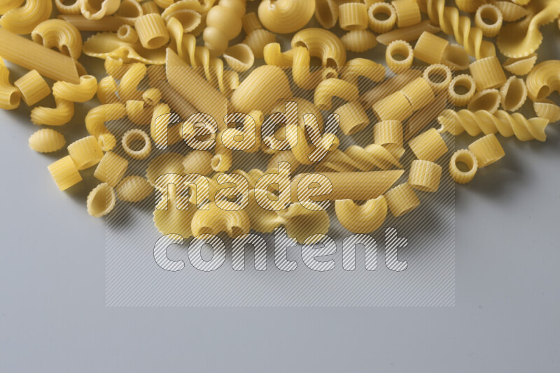 Different pasta types on light blue background