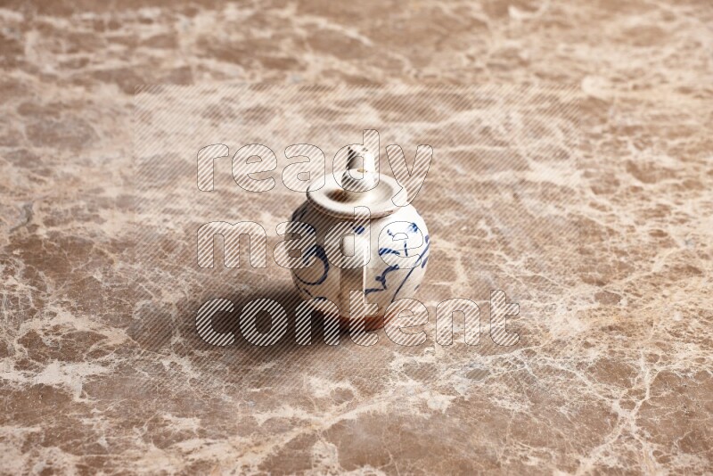 A pottery teapot on beige marble background