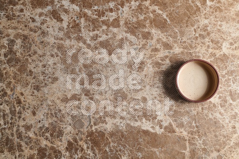 Top View Shot Of A Beige Pottery Oven Plate On beige Marble Flooring