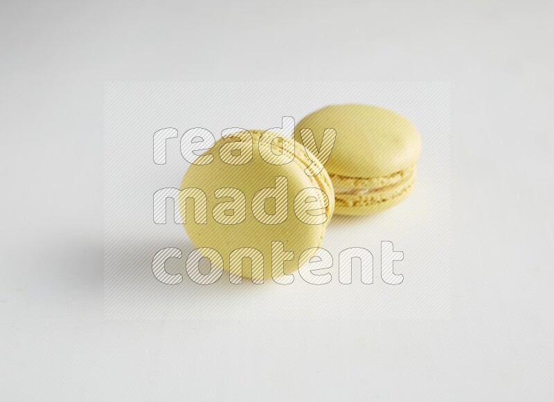 45º Shot of two Yellow Lime macarons on white background