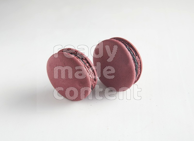 45º Shot of two Red Cherry macarons on white background