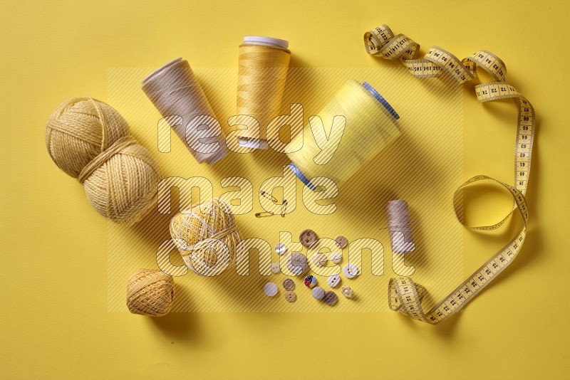 Yellow sewing supplies on yellow background