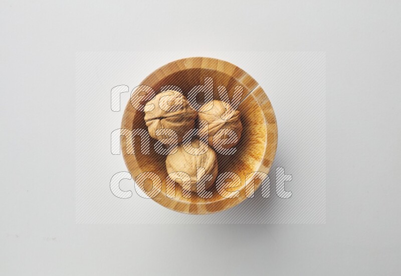 Top-view shot of walnut in a container on white background