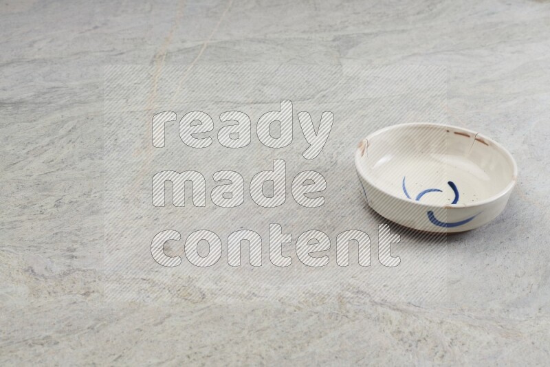 A multicolored pottery bowl on grey marble background