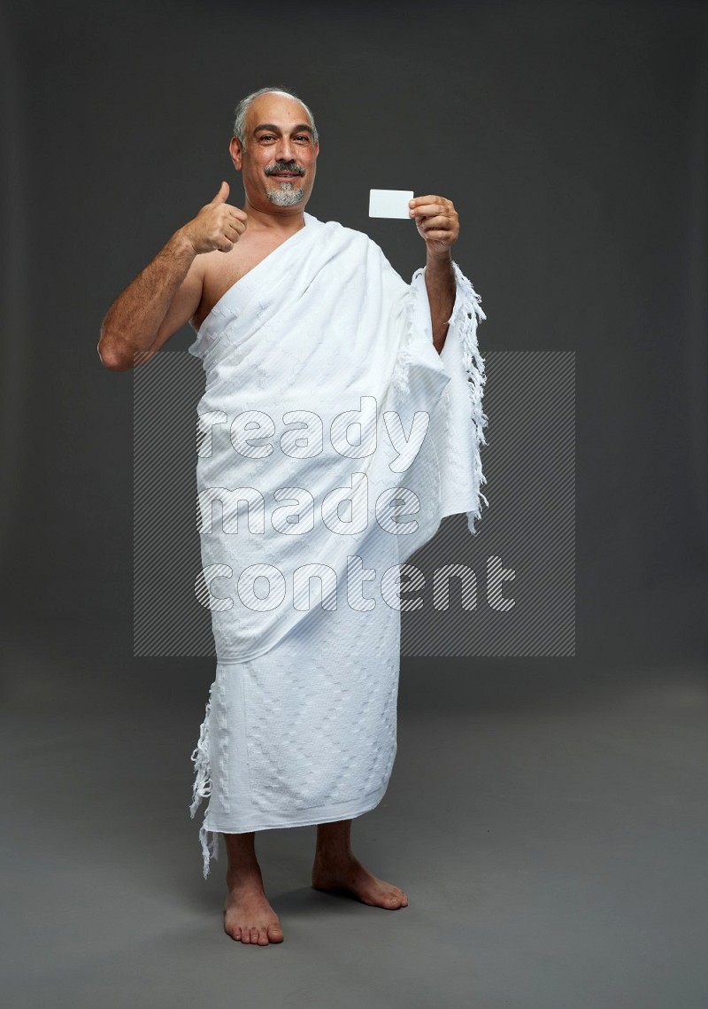 A man wearing Ehram Standing holding ATM card on gray background