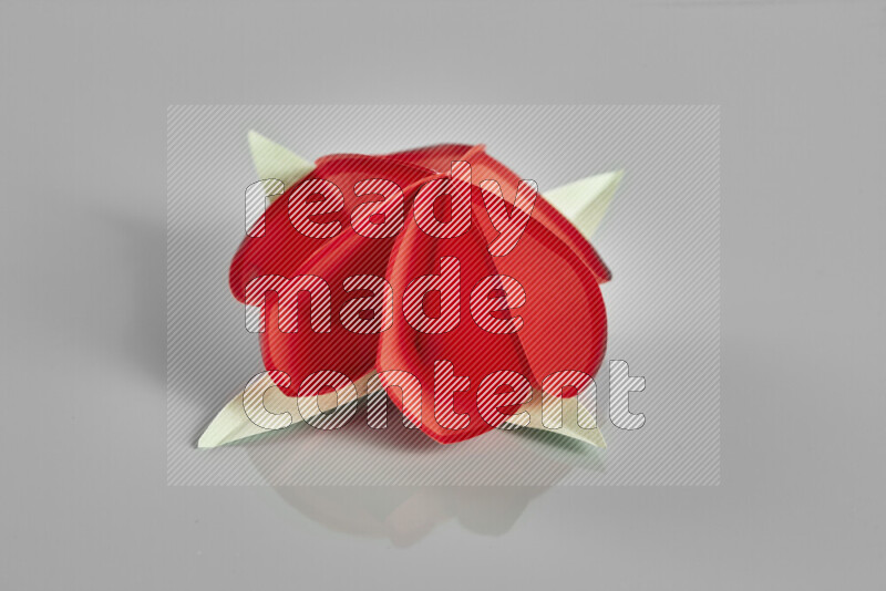 Origami flower on grey background