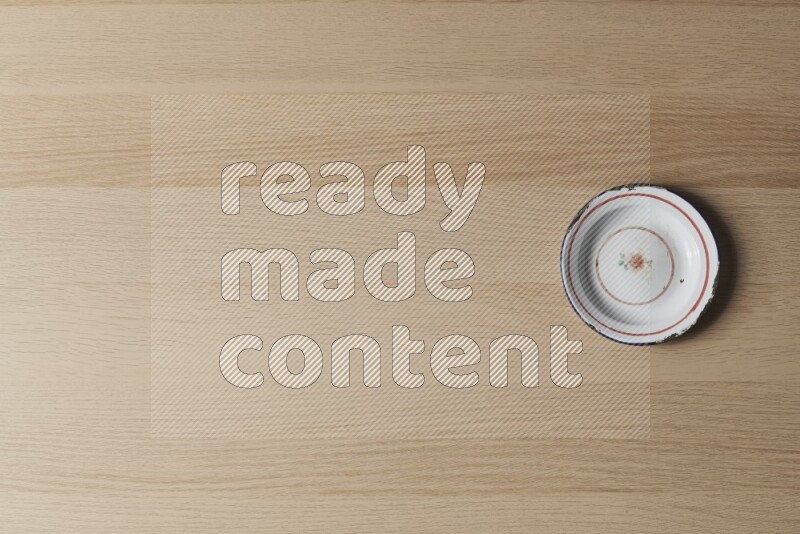 صحن معدني عتيق على خلفية خشبية فاتحة