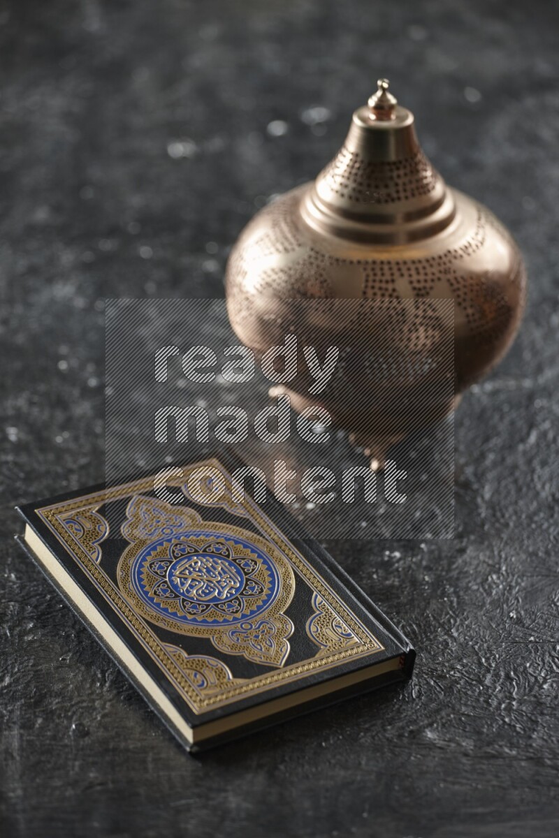 A golden lantern with different drinks, dates, nuts, prayer beads and quran on textured black background