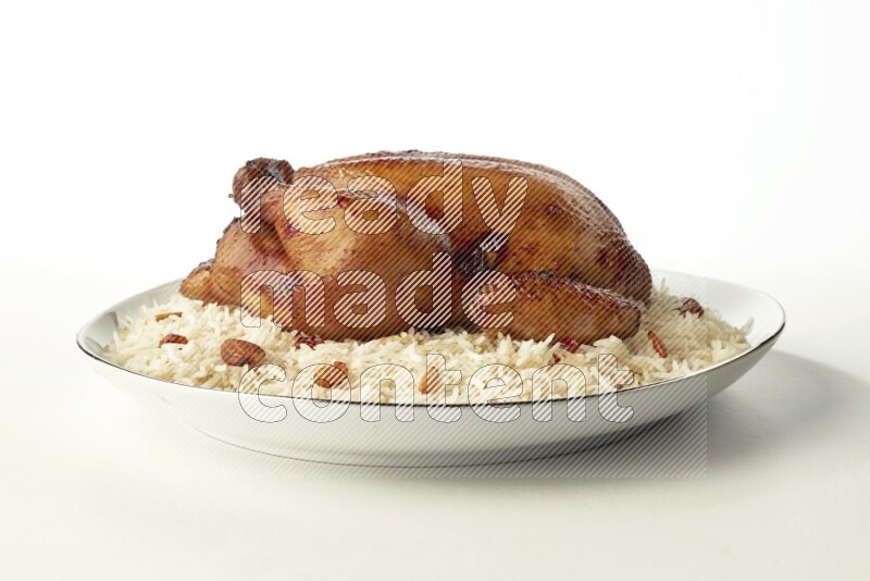 white  basmati Rice with  whole roasted chicken  on a white plate with a silver rim direct  on white background