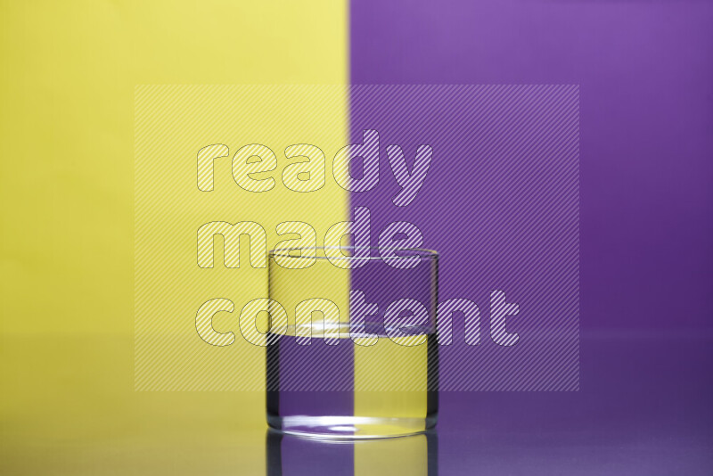 The image features a clear glassware filled with water, set against yellow and purple background