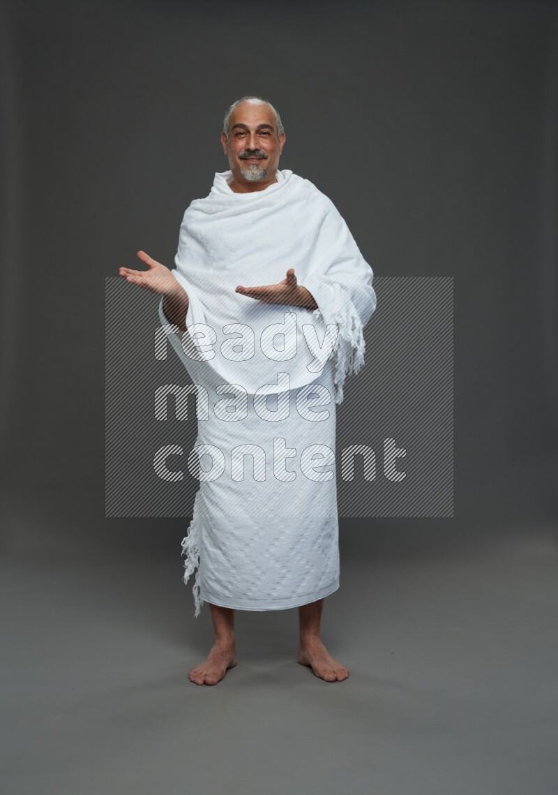A man wearing Ehram Standing Interacting with the camera on gray background