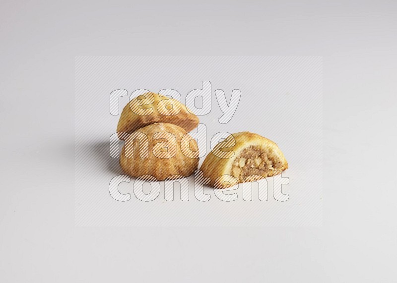 Three Pieces of Maamoul filled with walnut paste  one of them is cut direct on white background