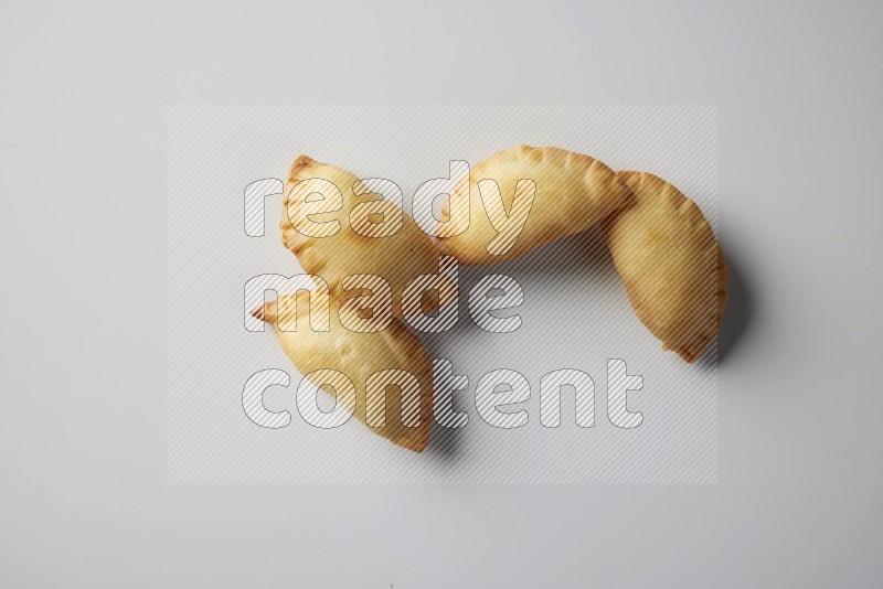 Four fried sambosa from a top angle on a white background