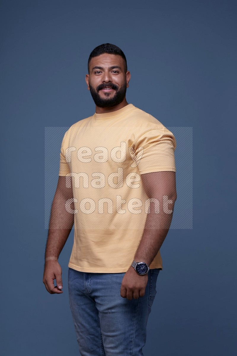 رجل يرتدي قميص اصفر بأكمام قصيرة وبنطال جينز ازرق يقف بأوضاع مختلفة
