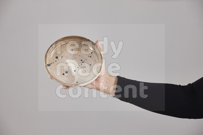 A woman in black abaya holding different pottery essentials in different positions