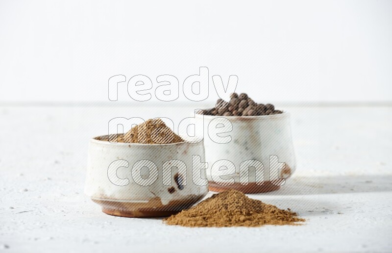 2 beige bowls, one full of powder and the other full of whole balls with balls and powder spreaded on a textured white flooring