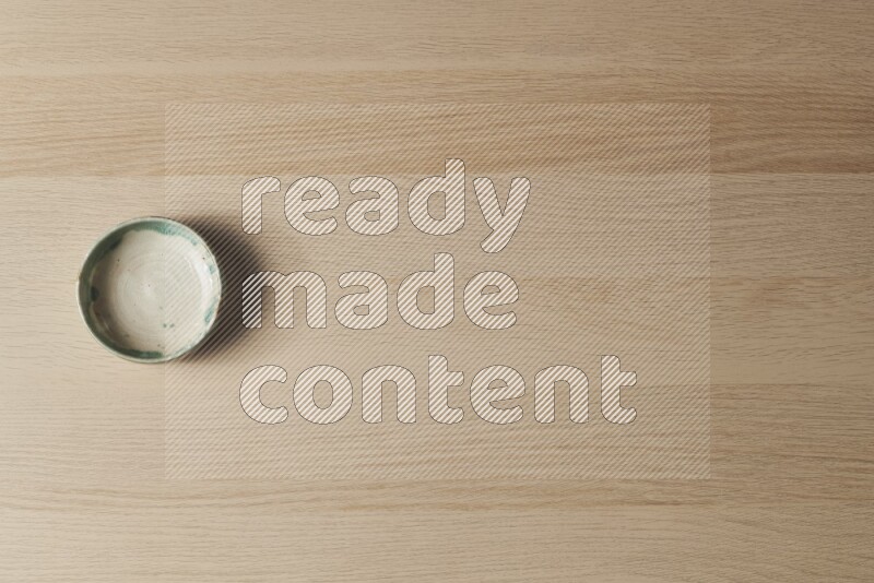 وعاء فخاري متعدد الألوان على خلفية خشبية فاتحة