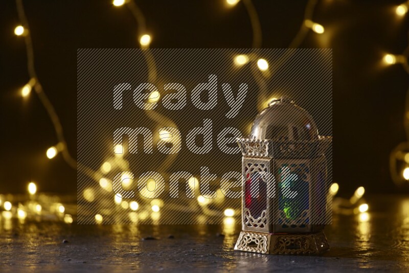 A traditional ramadan lantern surrounded by glowing fairy lights in a dark setup
