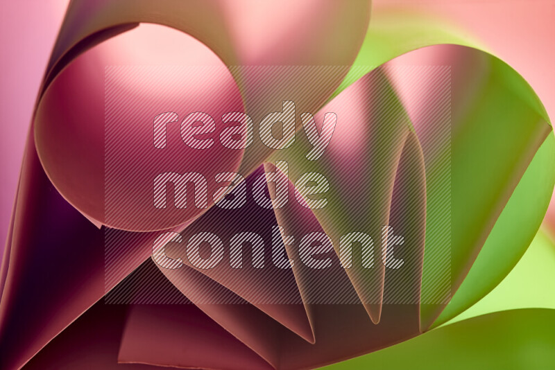 عرض فني لطيات الورق تخلق مزيج من الأشكال الهندسية، مضاءة بإضاءة ناعمة بدرجات اللون الأخضر والأحمر