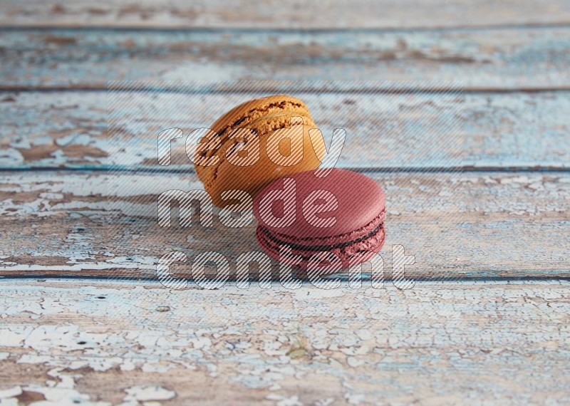 45º Shot of of two assorted Brown Irish Cream, and Red Cherry macarons  on light blue background