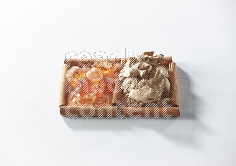 مربعان من أعواد القرفة ممتلئان بالزنجبيل المجفف والصمغ العربي علي خلفية بيضاء