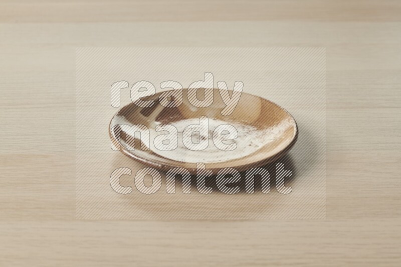 A multicolored pottery plate on light wooden background