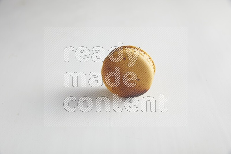 45º Shot of Yellow Crème Brulée macaron on white background