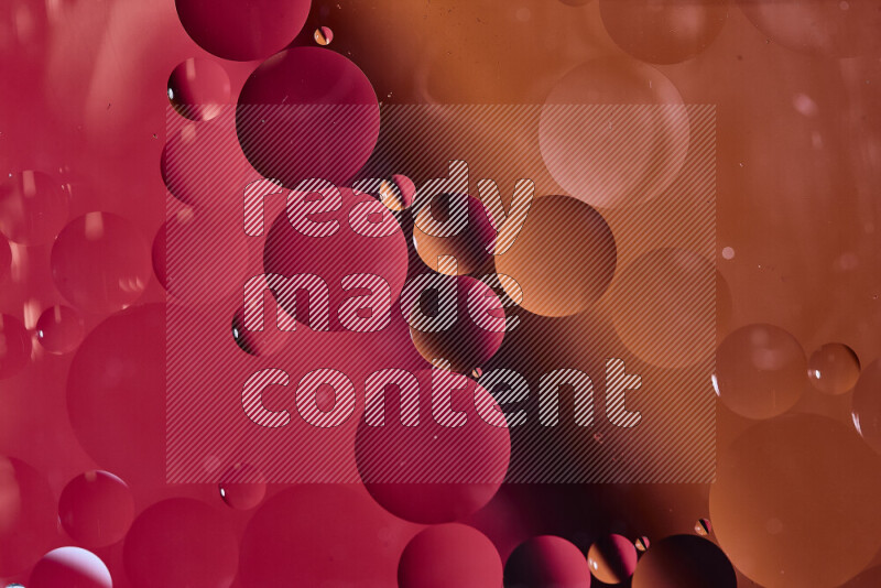 Close-ups of abstract oil bubbles on water surface in shades of red and orange
