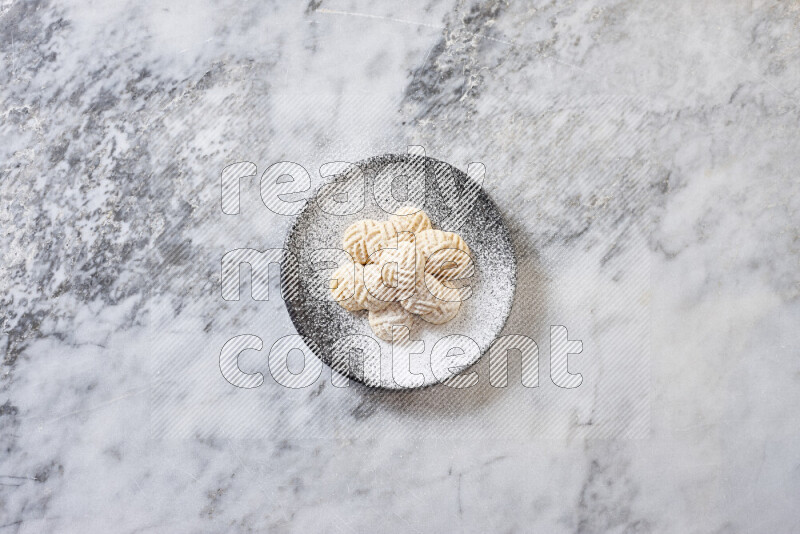 كحك في صحن فخار أسود على خلفية رخام رمادي