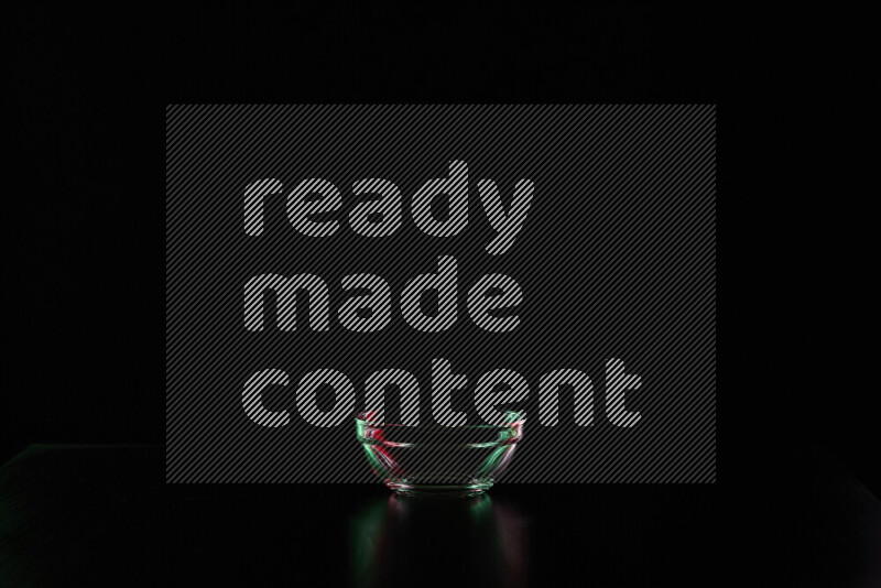 Glassware with rim light in red and green against black background