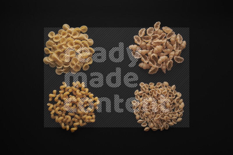 Different pasta types in bunches on black background