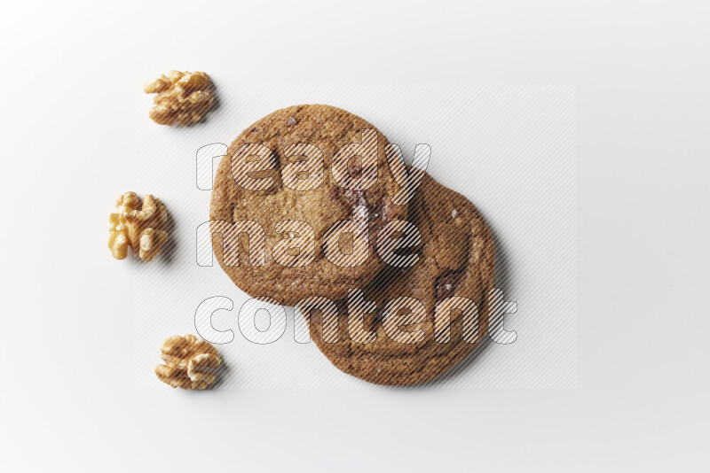 Chocolate chips cookies with walnuts beside it on a white background