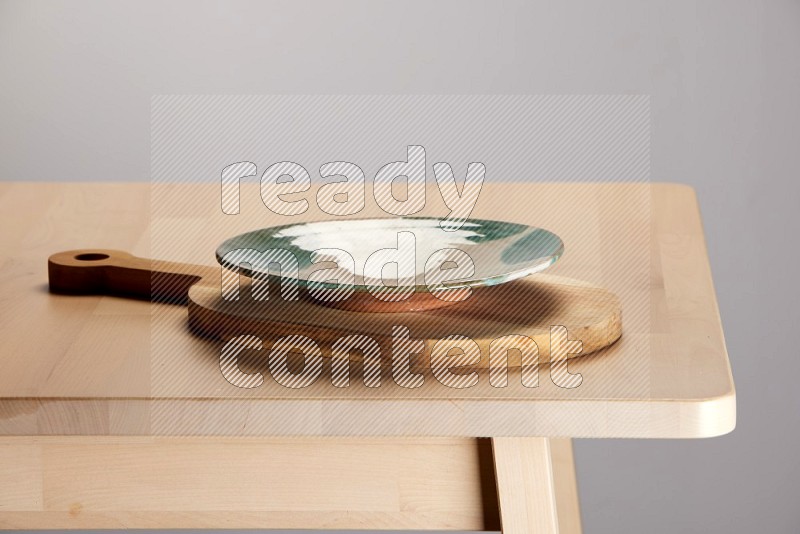 multi colored plate placed on a  wooden oval cutting board on the edge of wooden table