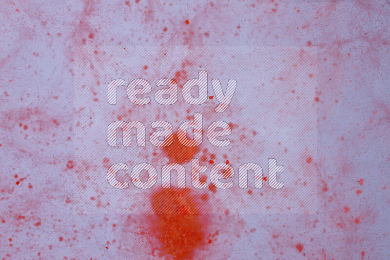 The image captures a dramatic splatter of red paint over a white backdrop