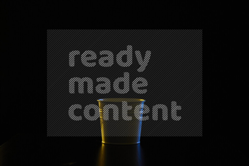 A plant pot with colored rim light against black background