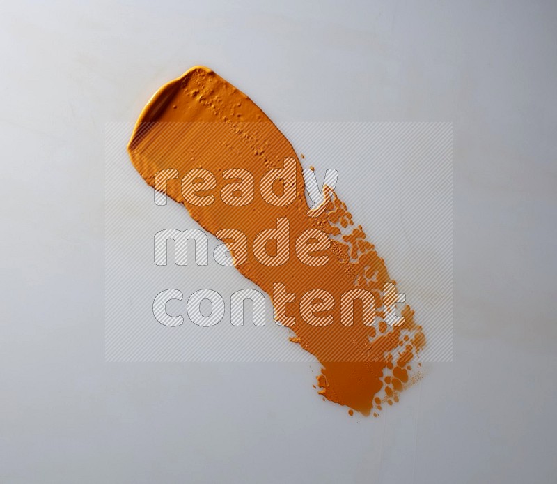 An orange straight painting knife stroke on white background
