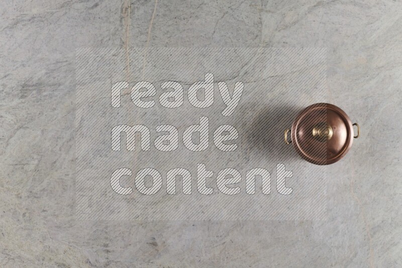 وعاء نحاسي صغير على خلفية من الرخام الرمادي