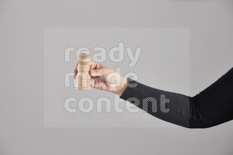 A woman in black abaya holding different wooden essentials in different positions