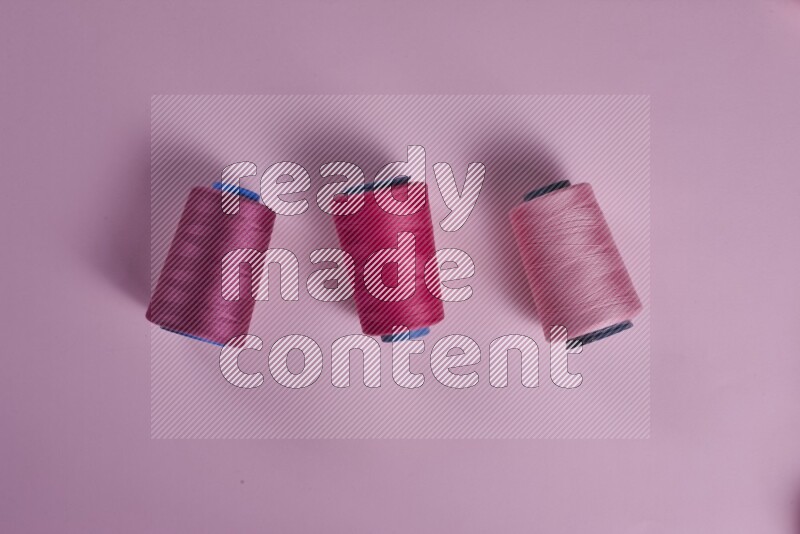 A pink collection of sewing and tailoring tools arranged on a pink background