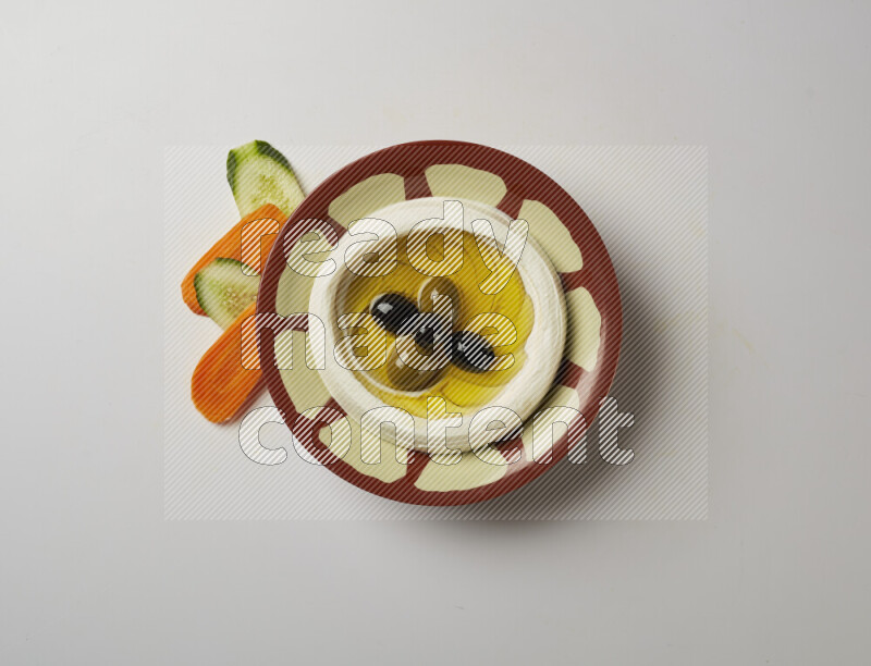 Lebnah garnished with olives in a traditional plate on a white background