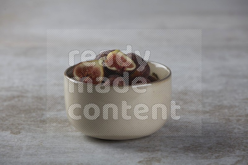 Fresh figs in a bowl on textured grey background