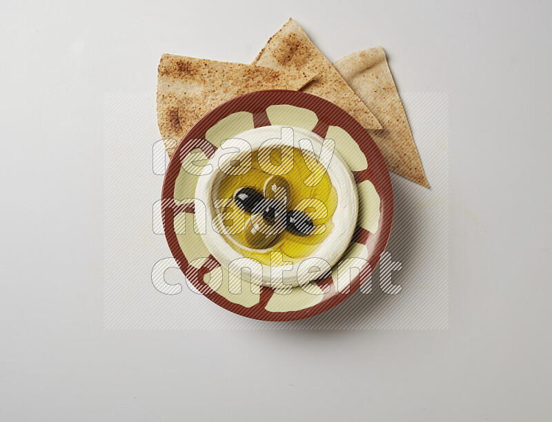 Lebnah garnished with olives in a traditional plate on a white background