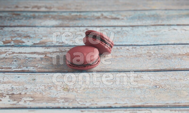 45º Shot of two Red Cherry macarons on light blue wooden background